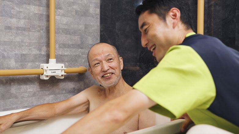 入浴介助を受ける男性とスタッフ