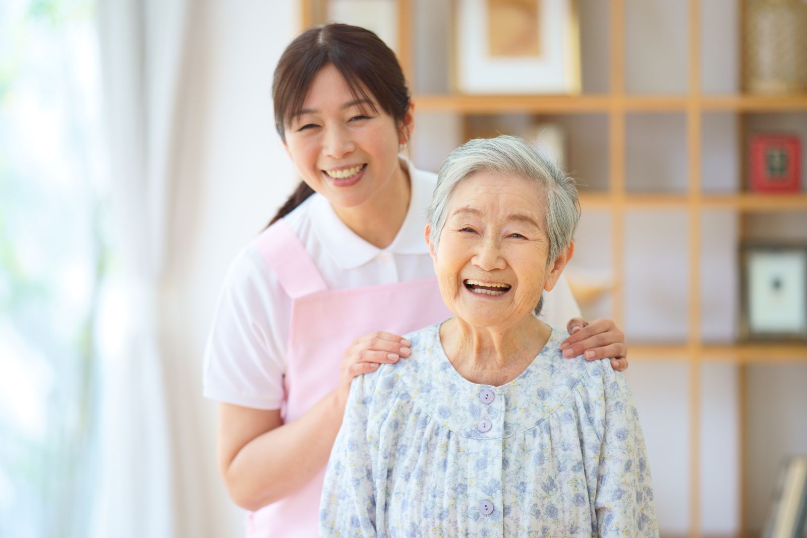 笑顔の高齢女性とスタッフ