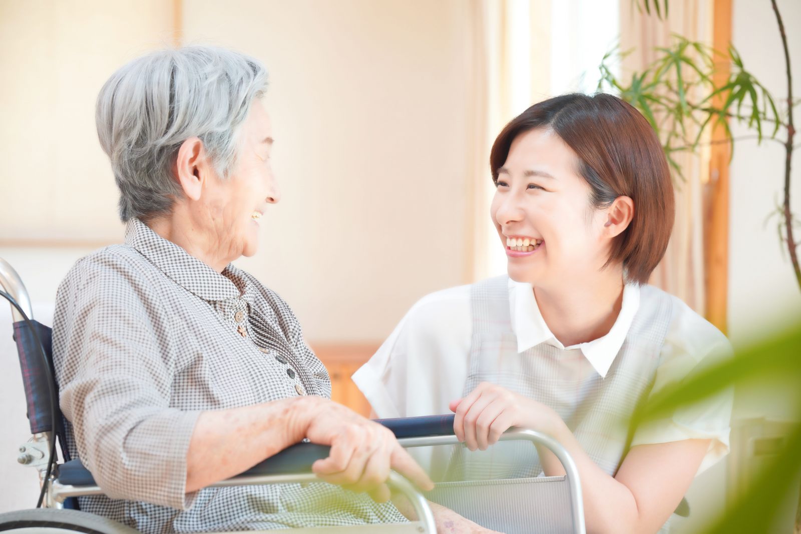 自宅で笑顔で過ごす高齢の女性とスタッフ