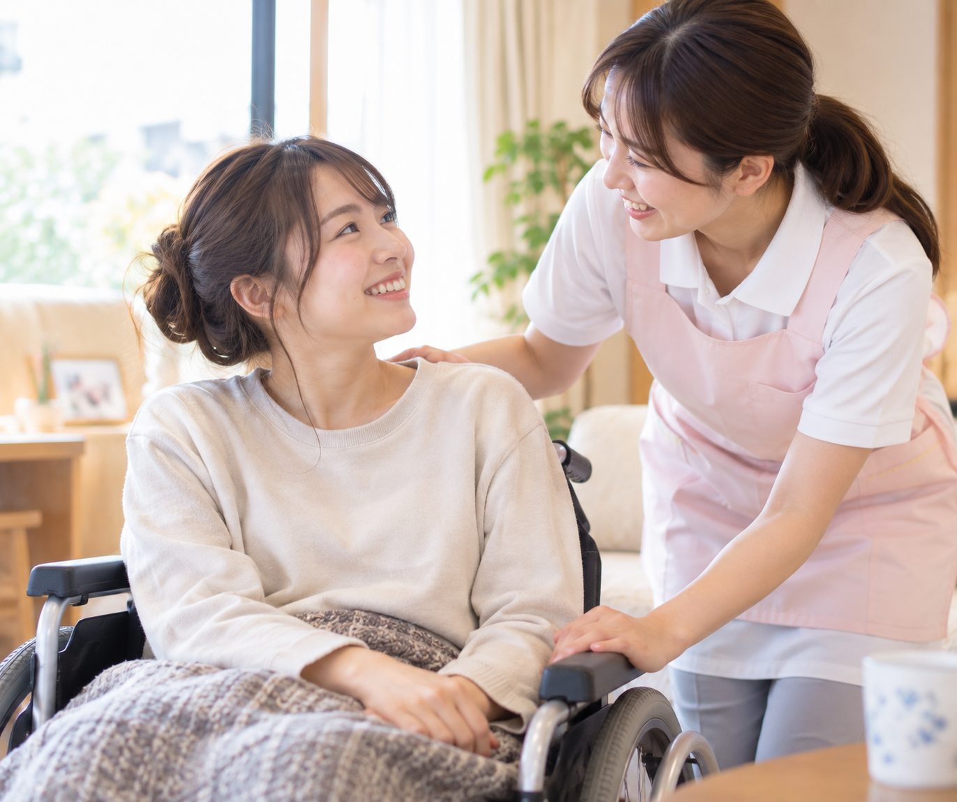 車いすの若い女性に寄り添い、笑顔で声をかけるスタッフ